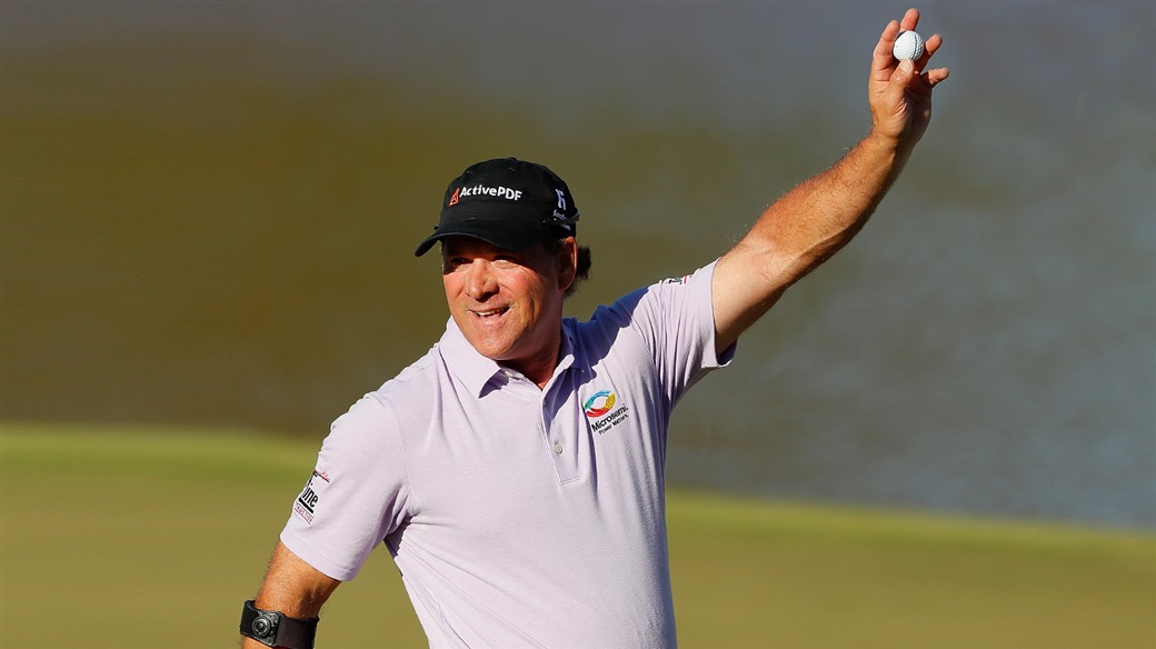 Scott McCarron raises his Titleist Pro V1 golf ball in victory after holing the last putt to win the 2019 Mitsubishi Electric Classic